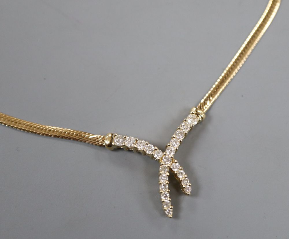 A modern Italian 9ct gold and diamond set stylised X necklace, approx. 42cm, gross 5.7 grams.